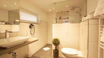 Un baño moderno con un lavamanos grande, inodoro y zona de ducha.