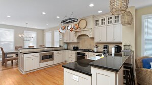 A spacious kitchen with a central island, built-in oven, and stainless steel appliances. - Awesome 4 bed/3.5 bath pup-friendly South End Home (Saint Simons Island)