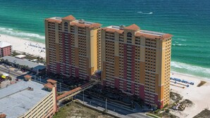 Un hotel de gran altura con varios balcones, situado cerca de una playa y con vista despejada al océano.