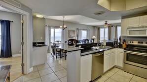 Una cocina moderna con una isla central, electrodomésticos integrados y un comedor con vistas.