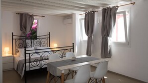 Une chambre à coucher avec un lit, une table de chevet, une lampe et une fenêtre avec des rideaux.