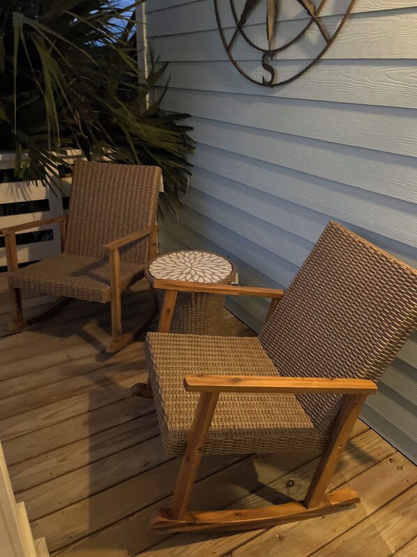 A wooden deck with wicker chairs and a small round table. - Amazing marsh view and close to beach! (Holden Beach)