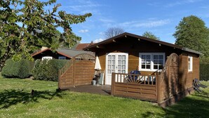 A wooden cabin with a porch, a door, and a window. - Blockbohlenhaus für 2 Personen (Gotthun)