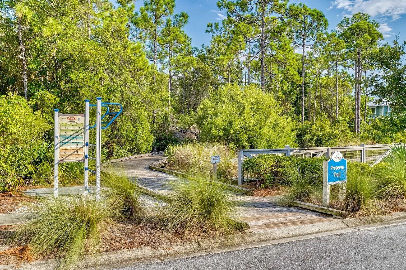 A trail entrance with signs indicating 'Preserve Trail' and 'ENERGI' with exercise steps.