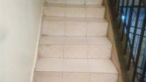 A staircase with beige patterned tiles and a metal railing. - Apex Guest Rooms (Juja)