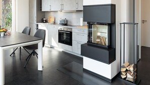 Una cocina moderna con horno empotrado, estufa blanco y negro y armarios grises.
