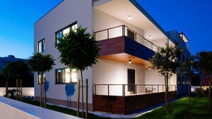 A modern two-story house with a balcony, large windows, and a well-lit exterior. - Lena Luxury Apartments (Zadar)