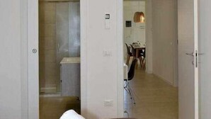 Una habitación de hotel con cama, baño y zona de comedor.