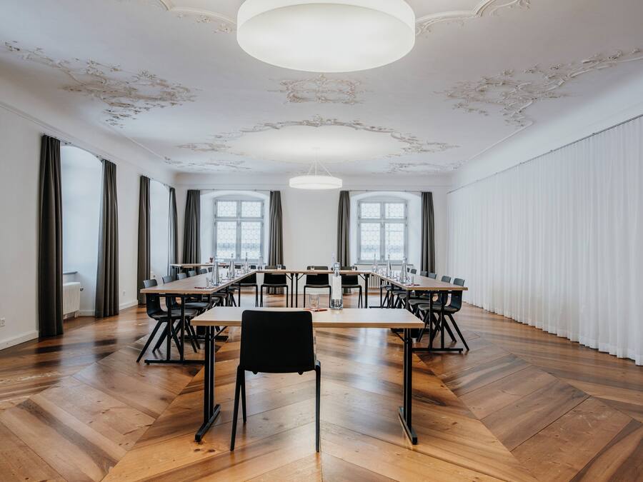 A conference room with a long table, chairs, and a chandelier.