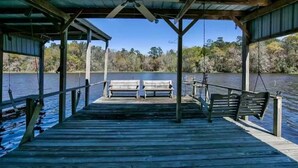 A wooden pier with benches and a swing, overlooking a body of water and trees. - Lake Talquin Fisherman's Paradise (Tallahassee)