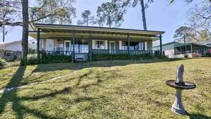 A two-story house with a covered porch and a small garden area with a birdbath. - Lake Talquin Fisherman's Paradise (Tallahassee)