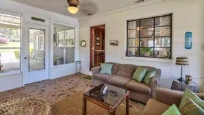 A cozy living room with a sofa, a coffee table, and a window with decorative items. - Lake Talquin Fisherman's Paradise (Tallahassee)