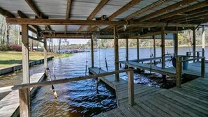 A covered dock area with wooden structures and a water body. - Lake Talquin Fisherman's Paradise (Tallahassee)