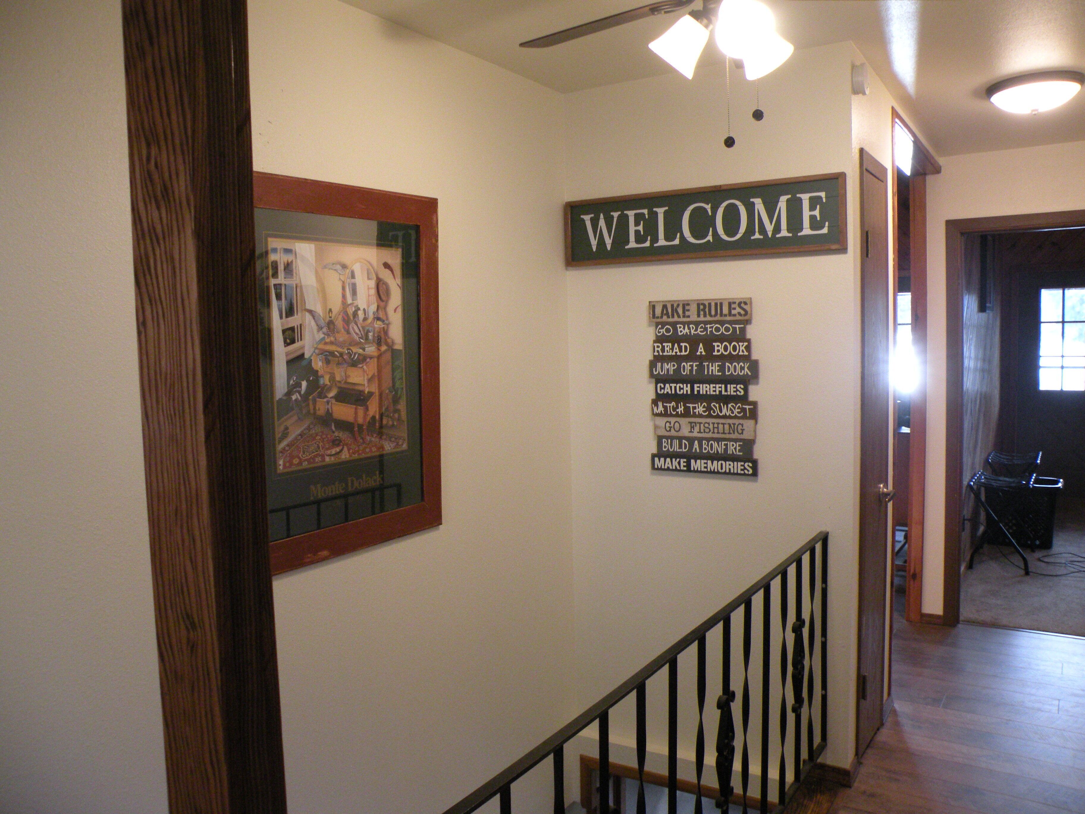 A hallway with a 'WELCOME' sign and a list of activities like 'Go barefoot' and 'Read a book'.