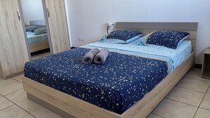 Makuuhuone, jossa on sänky, vaatekaappi ja yöpöytä.