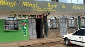 Un bâtiment portant une enseigne indiquant « Mingi Mingi Bar & Hotel ».