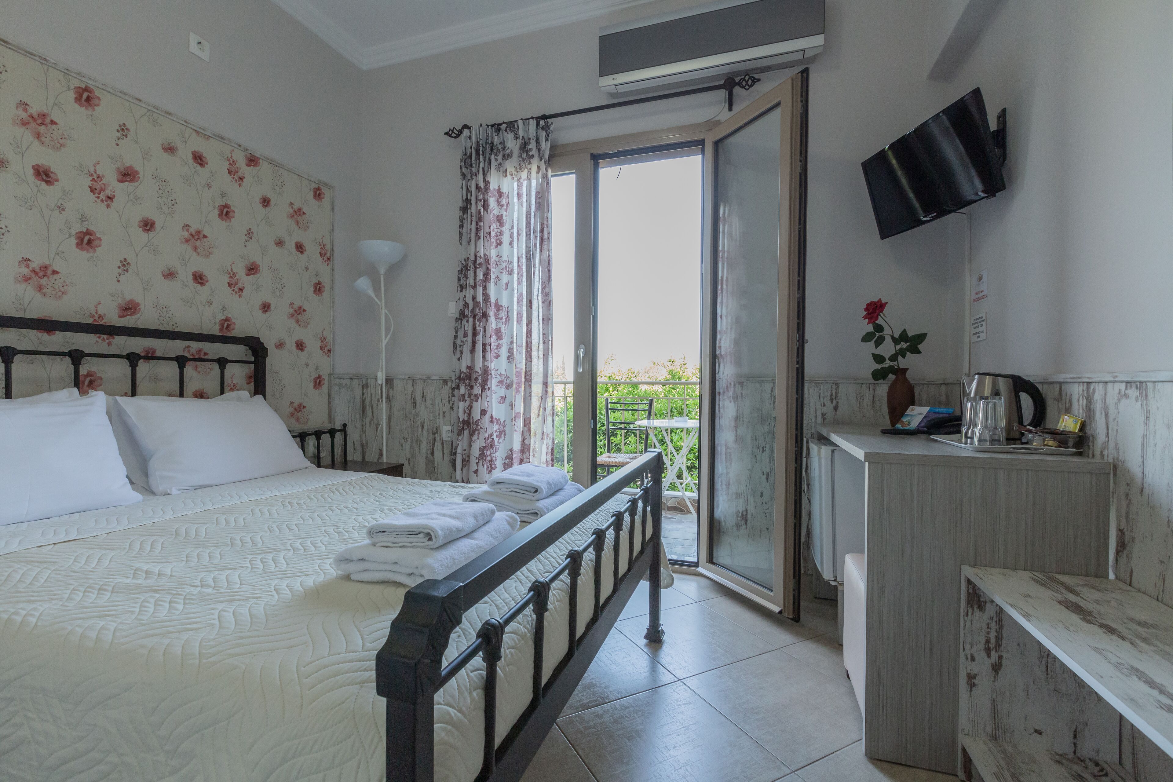 Un dormitorio con cama, escritorio y televisor.