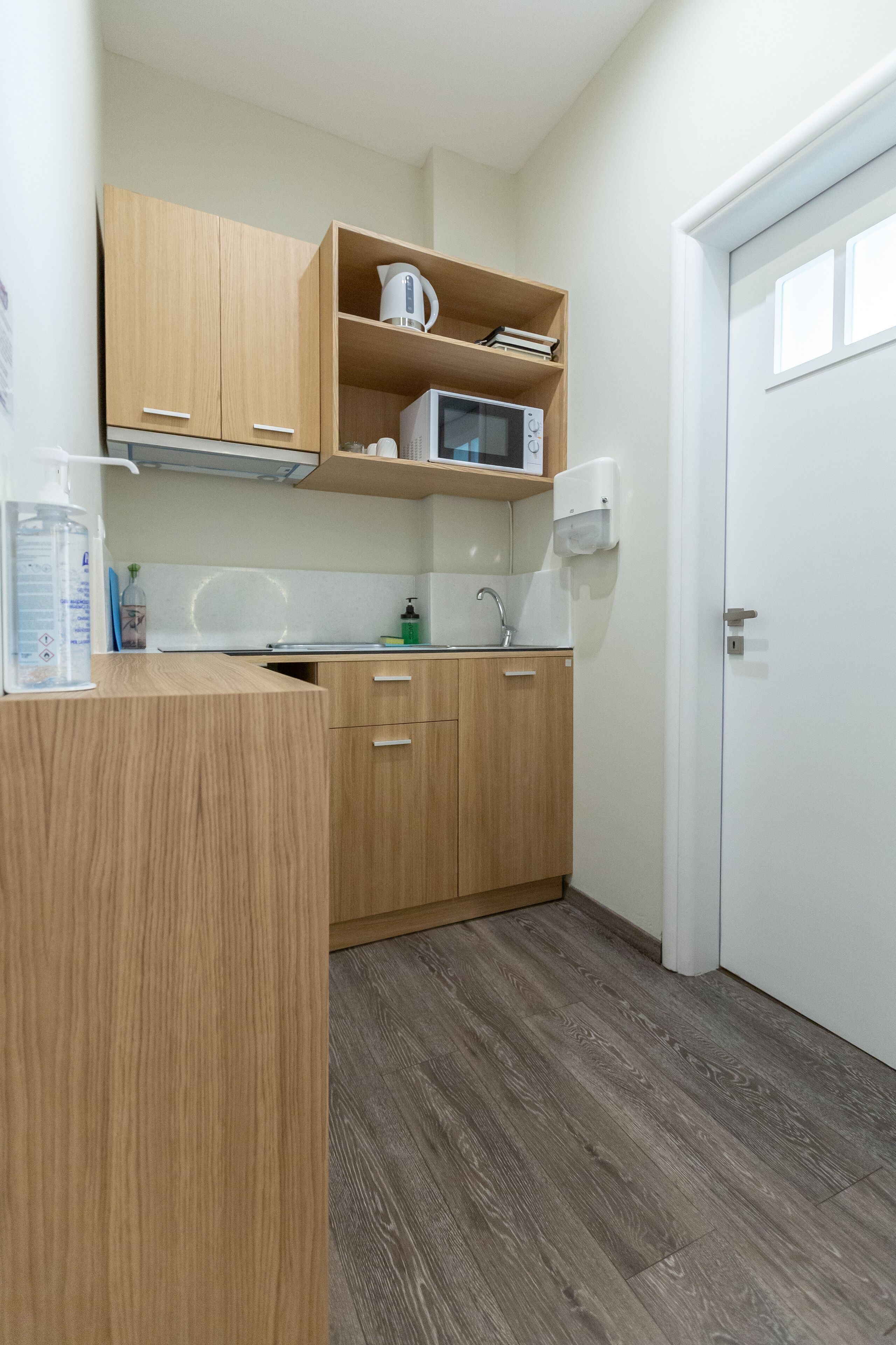 Una cocina funcional con armarios de madera, un microondas y un lavabo.