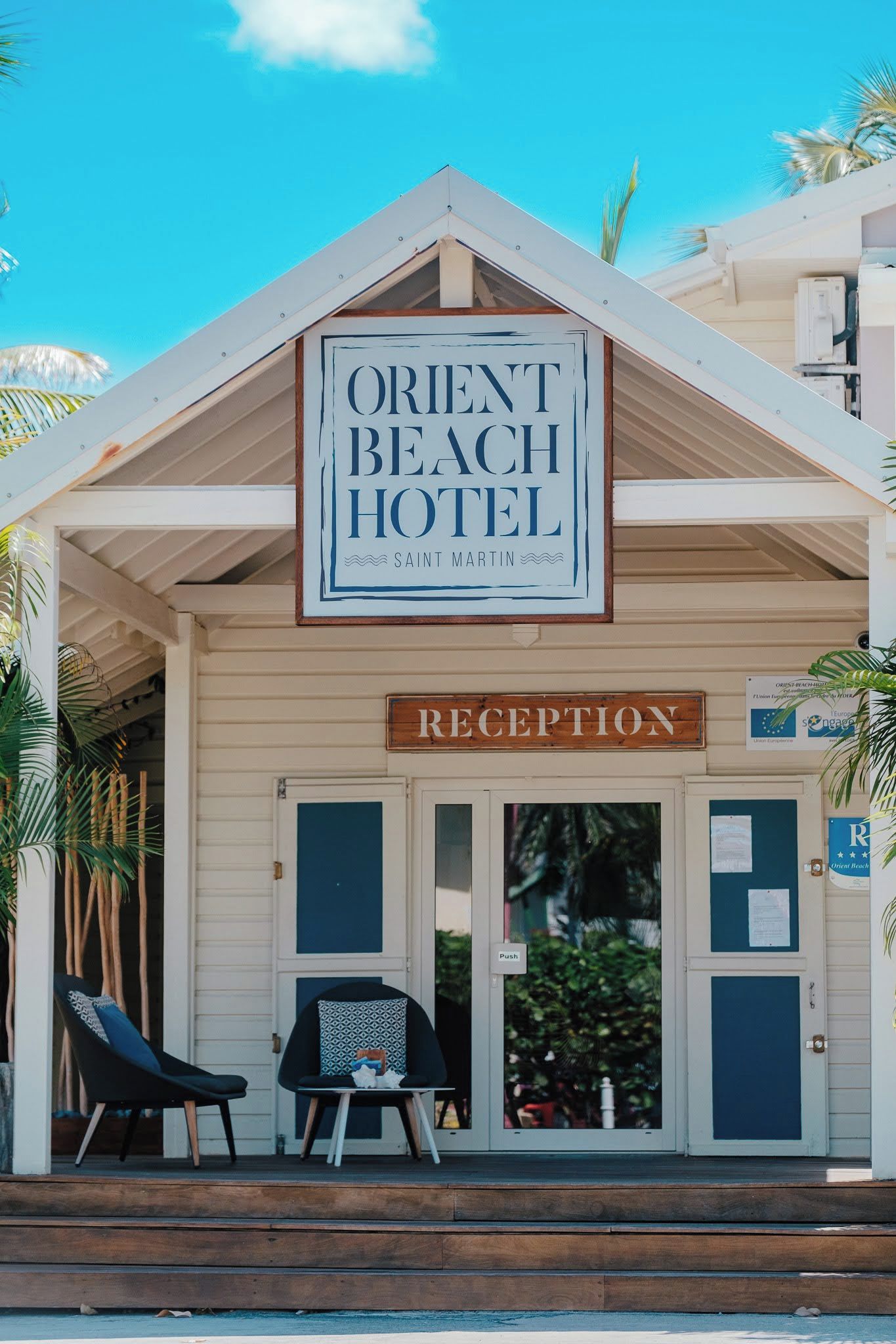 A hotel reception area with a sign for the Orient Beach Hotel and Saint Martin.
