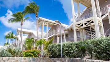A hotel with multiple floors, outdoor staircases, and palm trees.
