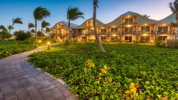 A multi-story hotel with a landscaped garden and palm trees. - Orient Beach Hotel (Orient Bay)