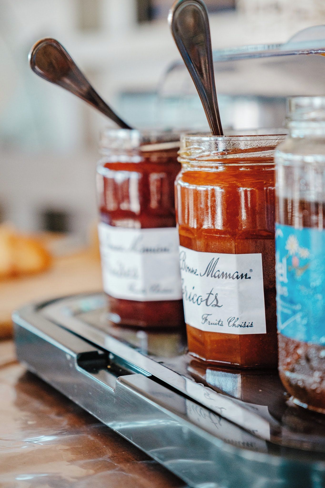 Three jars of preserves on a tray.
