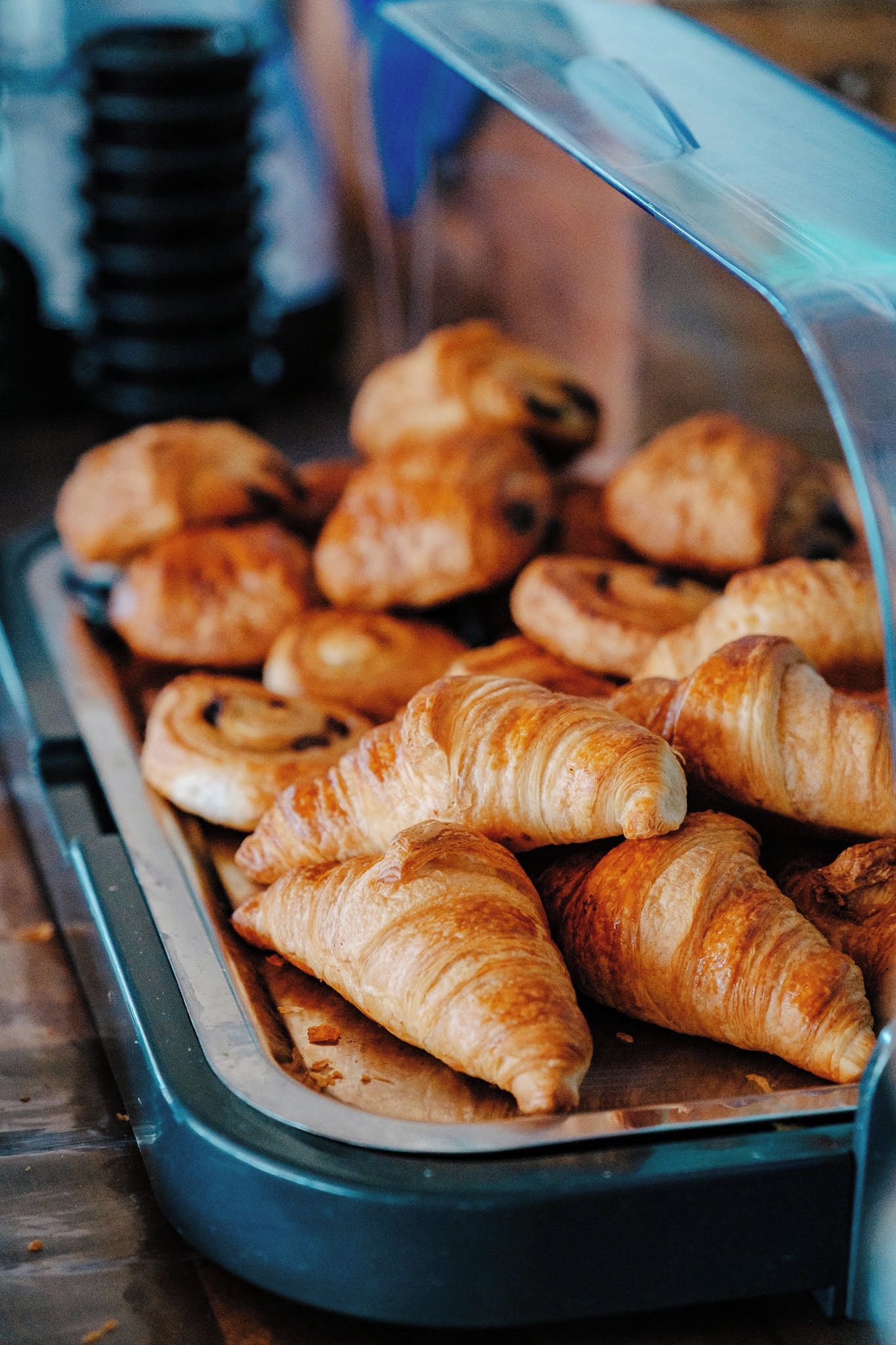Una vitrina llena de diversos pasteles, incluyendo croissants y otras delicias horneadas.