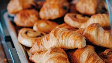 A display case filled with various pastries, including croissants and other baked goods.