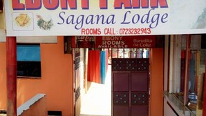 Señal de Ebony Park Sagana Lodge con un número de contacto para reservas de habitaciones.