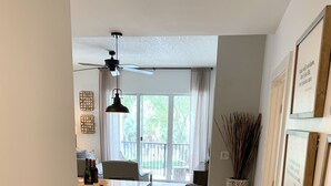 A modern kitchen with a dining area, a large window, and a view of the outdoors.