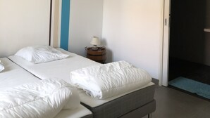 A hotel room with a bed, a bedside table with a lamp, and a door leading to another room. - Calm and relaxation in Champagne (Verneuil)