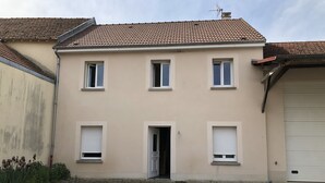 A two-story building with a tiled roof, a garage door, and a paved driveway. - Calm and relaxation in Champagne (Verneuil)