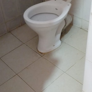 Un inodoro en un baño con piso de baldosas.