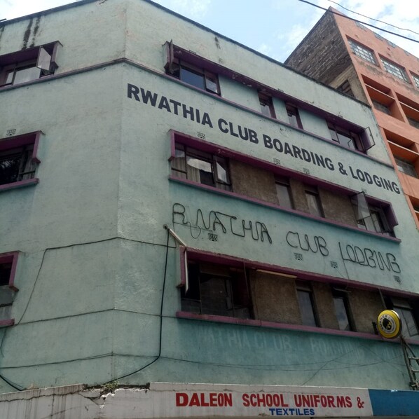 Un edificio con letreros que indican RWATHIA CLUB BOARDING & LODGING.