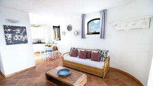 Una sala de estar con sofá, una mesa de centro y un comedor con sillas y una mesa.