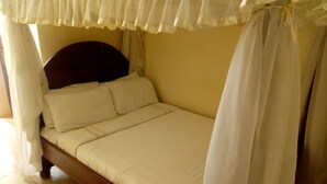 A bed with a canopy, wooden headboard, and white bedding. - Bungoma Midtown Hotel (Bungoma)