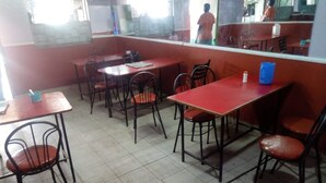 A dining area with tables and chairs, a tiled floor, and a window with a view of the outside. - Bungoma Midtown Hotel (Bungoma)