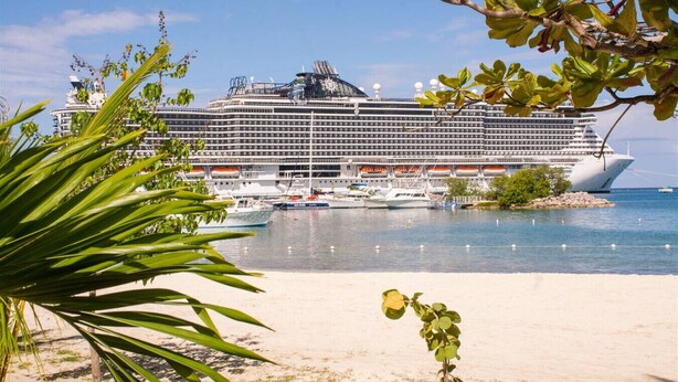 A large cruise ship docked at a port with a sandy beach in the foreground. - Emerald Corner @ Fisherman`s Point, Ocho Rios (Ocho Rios)