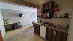 A modern kitchen with wooden cabinets, a built-in dishwasher, and a countertop with a kettle and a coffee maker. - Sleepat84 (Dullstroom)