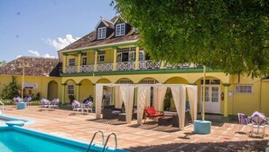 A pool area with lounge chairs and a covered seating area. - Sunburst Studio Suite @ Sandcastles Resort (Ocho Rios)