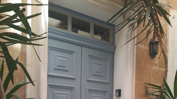 A blue double door with a mail slot, a small step leading up to it, and a potted plant to the right. - JM - Casa Rooms (Valletta)