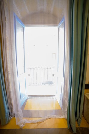 Ein offenes Durchgang zu einem Balkon mit Metallgeländer.