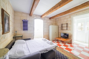 Quarto com cama, televisão, guarda-roupa e janela.