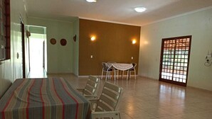 Una habitación amplia con una mesa de comedor y sillas, una puerta con diseño de cuadrícula y una pared decorada con círculos.