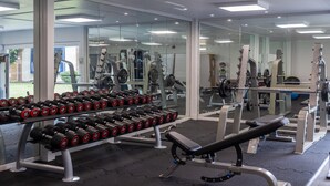 A gym with weightlifting equipment, including dumbbells and a bench. - Cambridge Bar Hill Hotel, BW Signature Collection (Cambridge)
