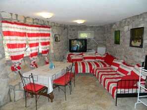 Relax in a rustic room with a dining area and seating space, featuring a TV and framed artwork.