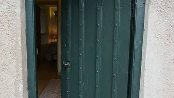 A green door with a metal handle, set in a stone archway.