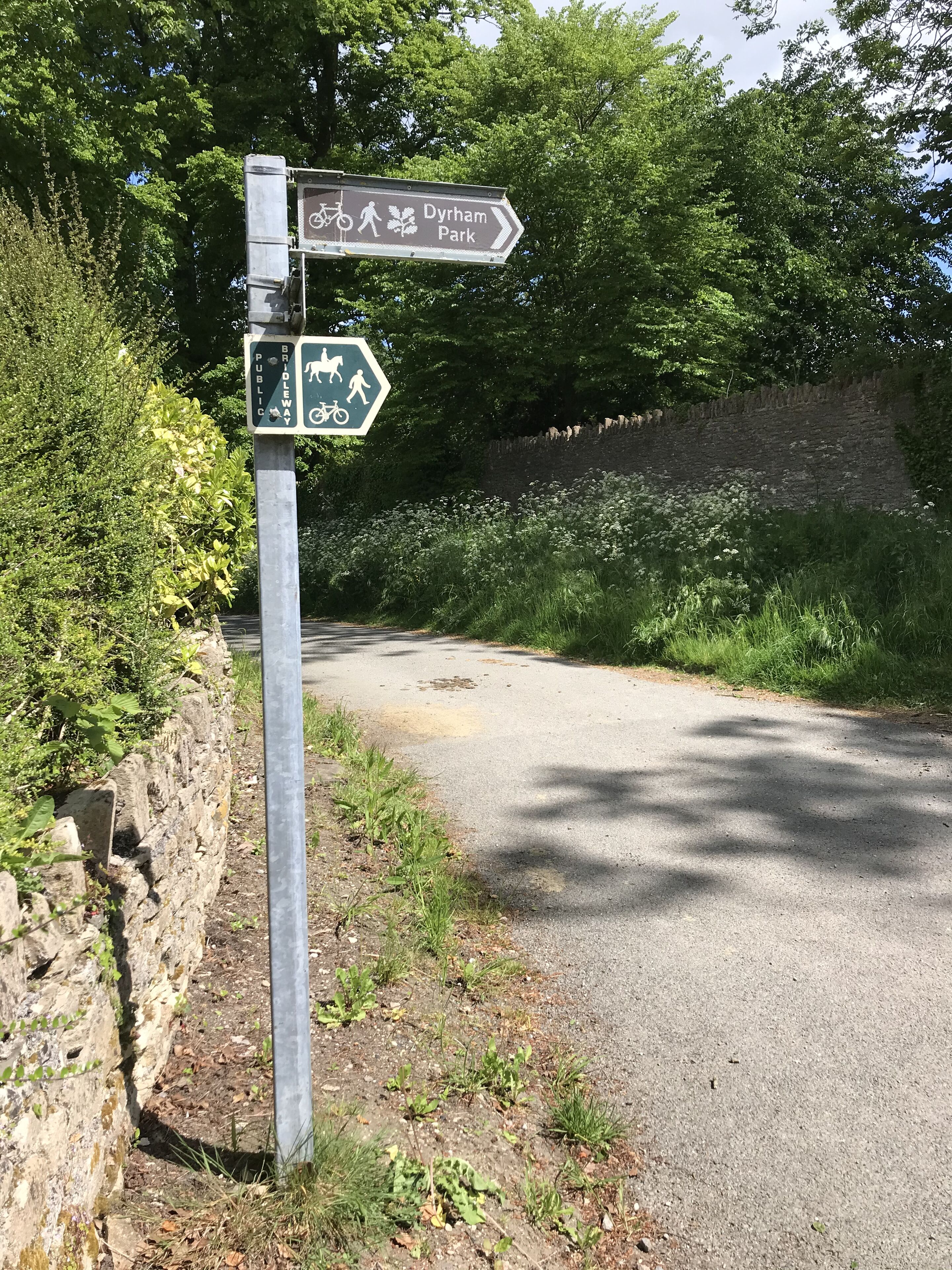 A directional signpost for Dyrham Park and a public bridleway.