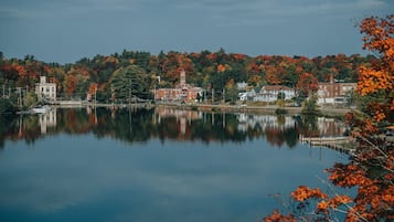 A calm lake with buildings and trees reflecting on the water.
