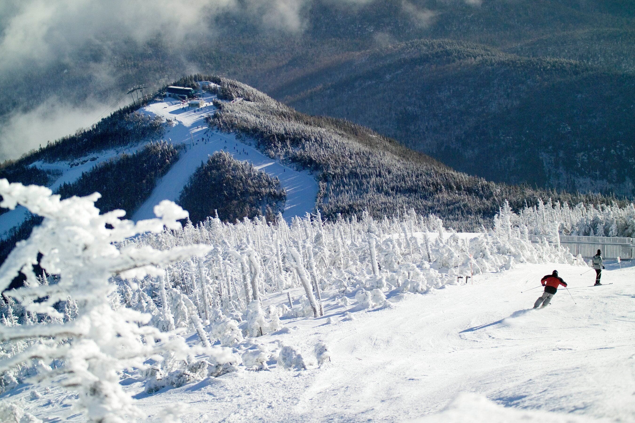Paisaje montañoso nevado con una pista de esquí.